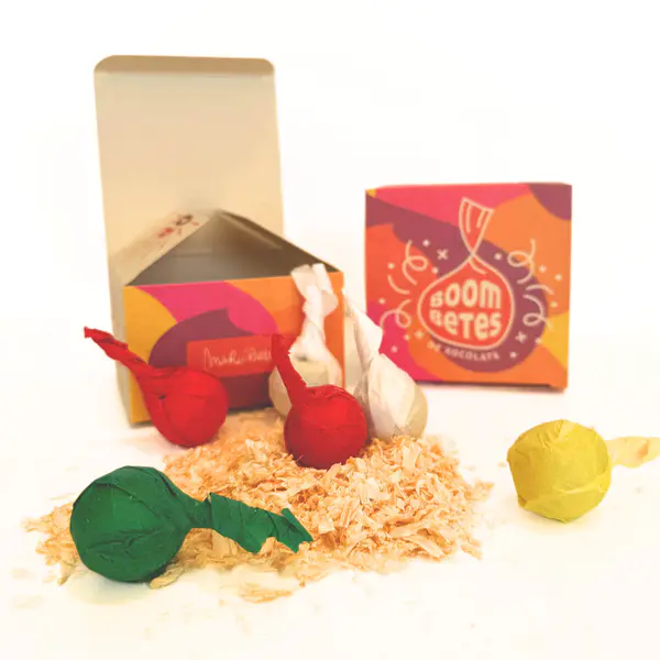 Pack bombetas de chocolate artesanas Mario Padial: bombones envueltos rojo/verde/amarillo sobre virutas, packaging Fallas valencianas, regalo gourmet de Valencia