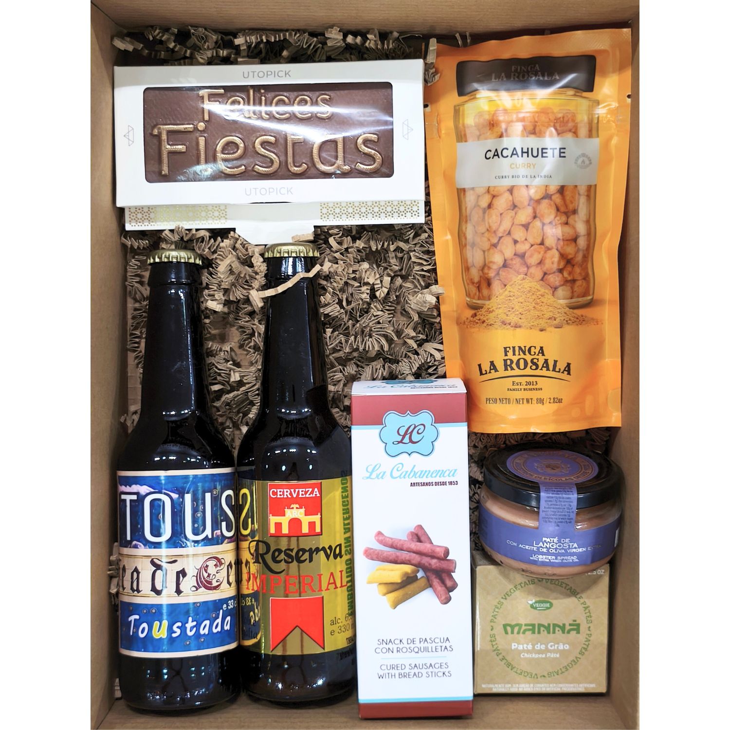 Interior caja gourmet 'Picoteo imperial' con cervezas, embutido, frutos secos, patés y chocolate